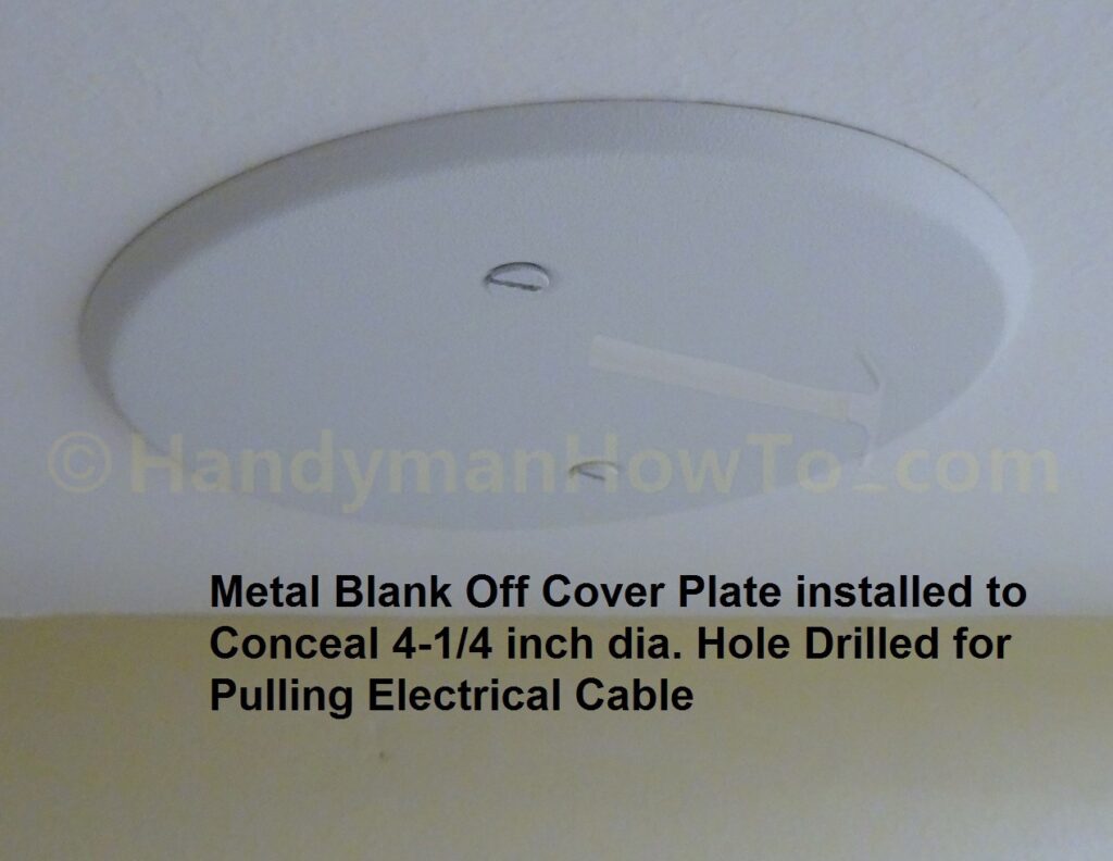 Metal Blank Off Cover Plate Installed on Drywall Ceiling to Cover Hole Cut for Fishing Electric Cable